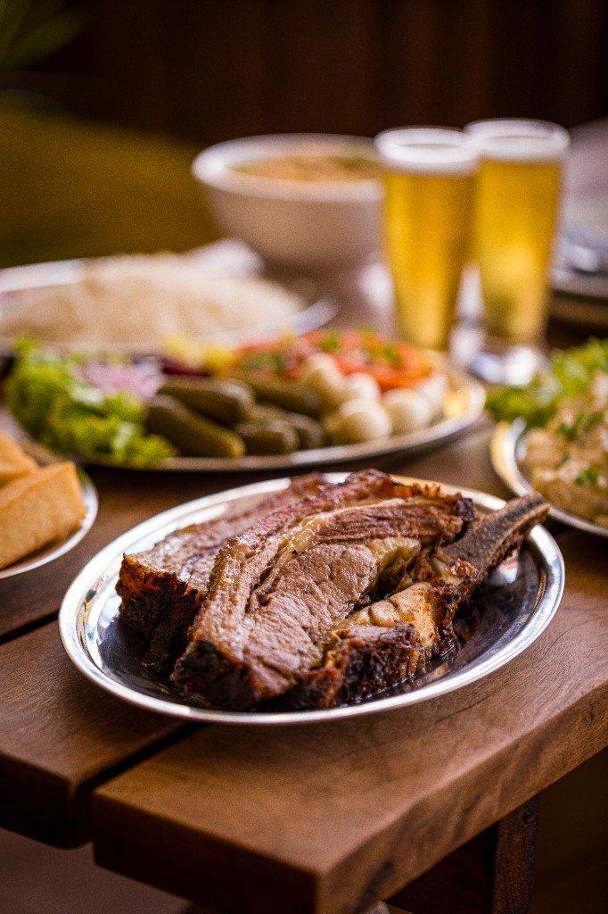 Costela assada com acompanhamentos e cerveja