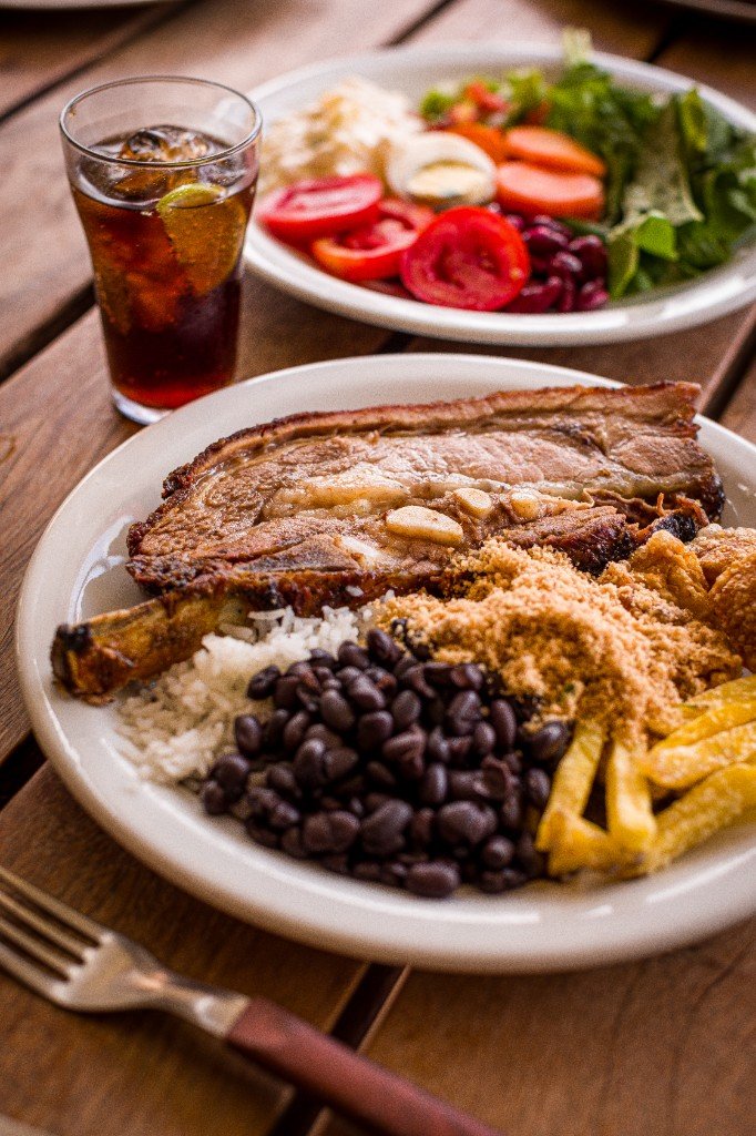 Prato com costela, arroz, feijão, farofa e mandioca