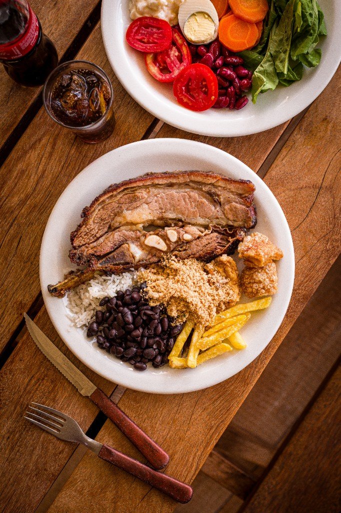 Prato com costela, arroz, feijão, farofa e refrigerante